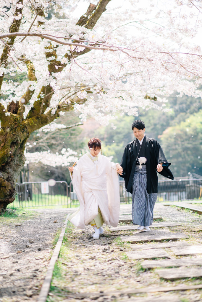 和装で桜の中を走る夫婦